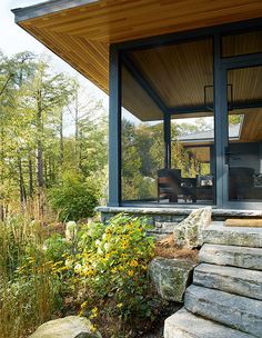 a house with large windows and stone steps leading up to it