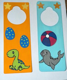 two door hangers decorated to look like dinosaurs and beach balls are on the table