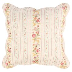 a pink and white striped pillow with flowers on the front, along with a red stripe down the middle