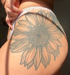 a woman's back with a sunflower tattoo on her lower half and bottom part