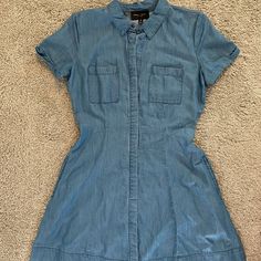 Nwot - Never Worn Beautiful A-Line Silhouette Denim Dress! Button Up Front With Denim Flap Covering The Buttons. Has 2 Side Pockets! Super Soft Material. Size M 100% Lyocell Approximate Measurements: Waist 28” Length ~33” Comment Any Questions And Feel Free To Make An Offer! Denim Blue Cotton Dresses With Buttoned Pockets, Denim Blue Cotton Button-up Dress, Button-up Denim Blue Cotton Dress, Short Sleeve Chambray Dresses With Pockets, Chambray Short Sleeve Dress With Pockets, Short Sleeve Denim Blue Cotton Shirt Dress, Denim Blue Chambray Short Sleeve Dress, Denim Blue Cotton Short Sleeve Shirt Dress, Denim Blue Cotton Shirt Dress With Short Sleeves