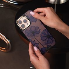 a person holding an iphone case with flowers on it