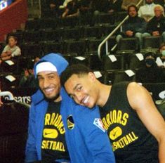 two basketball players are posing for a photo in front of an audience at a game