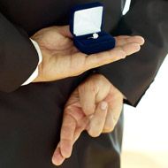 a man wearing a suit and tie holding an engagement ring in his lapel box