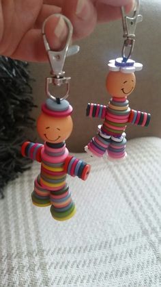 two small wooden dolls are being held by someone