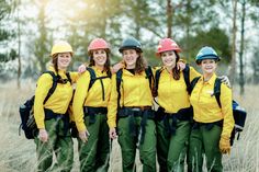 a group of women wearing hard hats and green pants