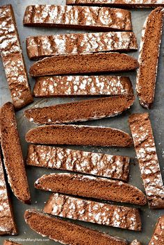 chocolate brownies with powdered sugar on top are lined up on a baking sheet