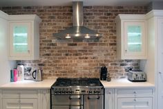 a stove top oven sitting inside of a kitchen next to white cabinets and counter tops