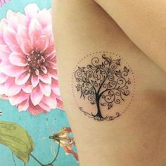 a woman with a tattoo on her arm has a pink flower in the shape of a tree