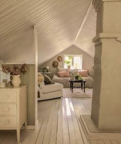 a living room with white walls and wooden flooring in the middle of it's attic