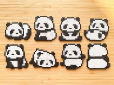 six pixelated panda bears sitting on top of a wooden table