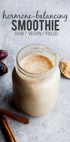 a glass jar filled with smoothie next to cinnamon sticks and anise on the side