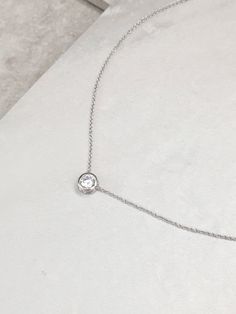 Elegant White Gold Round CZ Pendant Necklace: 16K White Gold finish, rhodium plated over high quality brass. Makes a beautiful gift for the Bridal Party or any occasion. Length 18inches (optional 1 inch extension when requested) CZ Charm 4mmx3mm Material 16K white gold, rhodium plated SKU: NCZ104 To prolong the beauty and quality of your new Lovely By Grace jewelry follow these simple care tips: Remove before showering, exercise, swimming and before bed as perfume, body oils and excessive perspi Silver Round Pendant Necklace With Prong Setting, Silver Diamond Necklace With Single Diamond, Dazzling Silver Diamond Necklace With Single Diamond, Silver Necklace With Single Diamond Round Pendant, Silver Diamond Necklace With Single Round Stone, Silver Wedding Solitaire Necklace With Single Diamond, Silver Necklace With Single Round Diamond, Silver Solitaire Necklace With Single Diamond For Wedding, Silver Crystal Necklace With Prong Setting