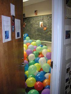 the door is open and there are many balloons in it