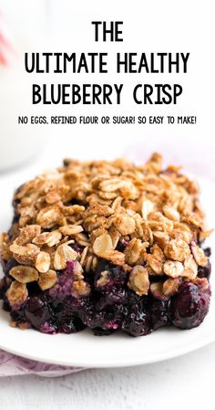 blueberry crisp on a white plate with the title text overlay reads the ultimate healthy blueberry crisp no eggs, refried flour or sugar so easy to