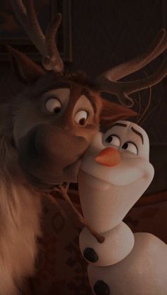 a close up of a person kissing a frozen king character with reindeer antlers on his head