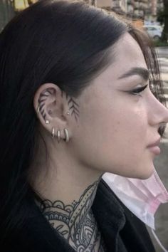 a woman with tattoos on her neck and ear