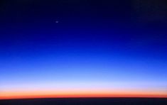 the view from an airplane window at sunset or sunrise, looking down on the horizon