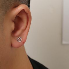 a close up of a person wearing a pair of ear piercings on their ears