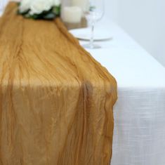 the table is set with white flowers and candles on it, along with wine glasses