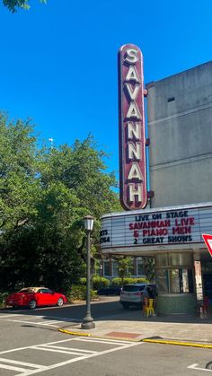 an old movie theater with cars parked in front