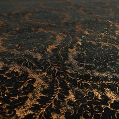 an intricately designed table top with gold and black paint on the surface is seen from above