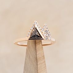 a diamond ring on top of a wooden stand