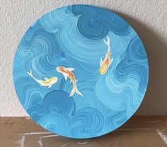 a blue plate with two gold fish on it