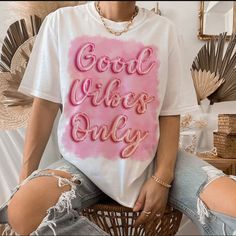 a woman wearing a t - shirt that says good vibes only in pink letters