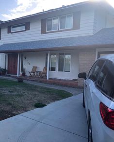 a white car parked in front of a house