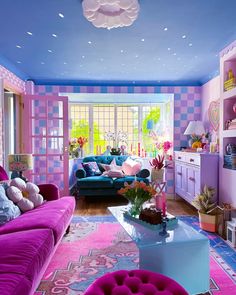 a living room filled with purple couches and lots of pink rugs on the floor