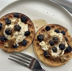 two waffles on a plate with blueberries and cream