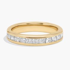 a yellow gold wedding ring with princess cut diamonds on the side and channeled in white stones