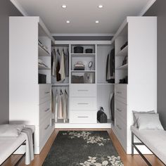 a walk in closet filled with lots of white cabinets and drawers next to a rug