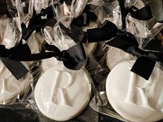 two decorated cookies in plastic wrappers with black ribbons