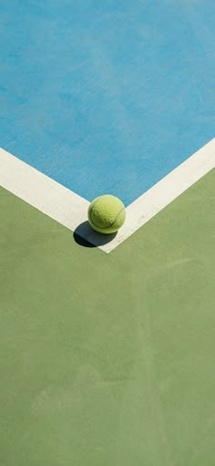 a tennis ball sitting on the edge of a court