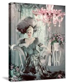 an old fashion photo of a woman sitting on a chair with flowers in the background