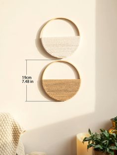 two circular wooden wall hangings on the wall next to a potted plant in a living room