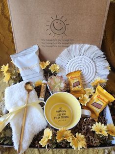 a box filled with yellow flowers and chocolates on top of a table next to a white doily