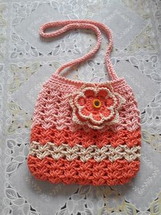 a crocheted purse sitting on top of a lace doily covered tablecloth