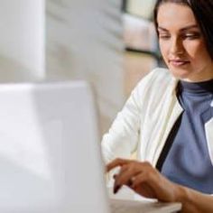 a woman sitting in front of a laptop computer