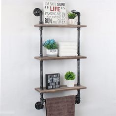 an industrial pipe shelving unit with three shelves and two towels on the bottom shelf