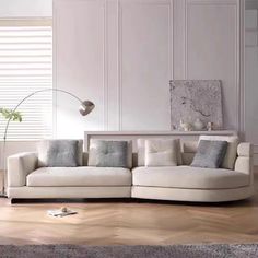 a modern living room with white furniture and wood flooring is pictured in this image