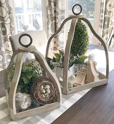 two bird's nest shaped planters sitting on top of a table next to a window