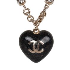 This Chanel necklace features a reversible Black glitter enamel heart charm with the classic CC motif on the front and a crystal embellished CC heart charm design on the reverse side. The chain is silver tone in a Rolo design with 6 black beads and faux crystals near the heart charm. The necklace features a lobster claw closure. Origin: France Condition: New and never worn Accompanied by: Chanel box and pouch, retail UPC Measurements: Chain 9" Pendant .75" x .75" Luxury Black Necklace With Logo Charm, Luxury Silver Necklace With Black Enamel, Luxury Heart-shaped Enamel Jewelry, Elegant Enamel Necklace With Heart Charm, Luxury Silver Heart Necklace With Heart Charm, Luxury Black Heart Pendant Necklace, Black Metal Jewelry With Logo Charm, Luxury Metal Jewelry With Heart Charm, Luxury Heart-shaped Charms Necklace