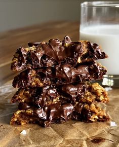 chocolate chip cookies stacked on top of each other next to a glass of milk