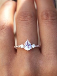 a woman's hand with a ring on it and an engagement band in the middle