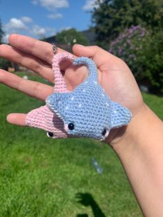 a hand holding a small crocheted animal in it's palm