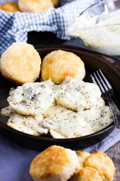 biscuits and cream on a black plate with a fork next to the bowl full of biscuits