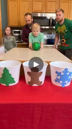 a group of people sitting around a table with cups on it and paper snowflakes in front of them